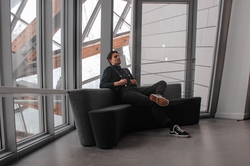 An elegant business traveler reviewing documents in a minimalist lounge with black and green accents.