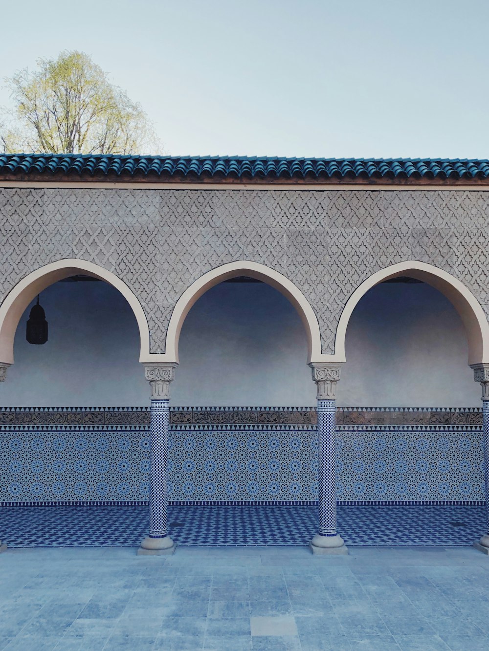 a row of blue and white arches next to a building