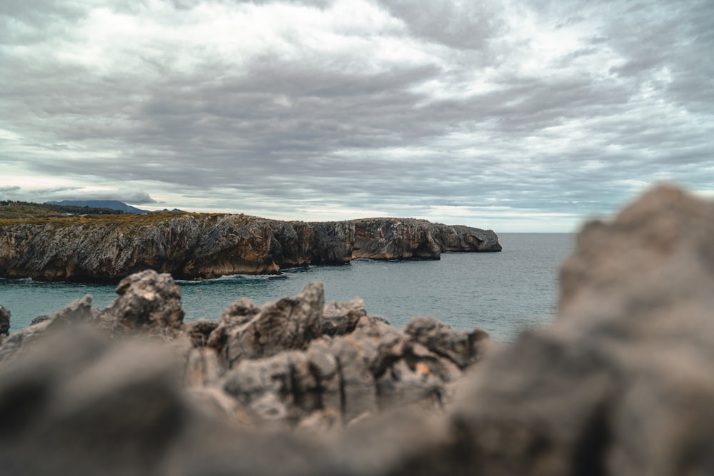 gray rock formation on sea at daytime