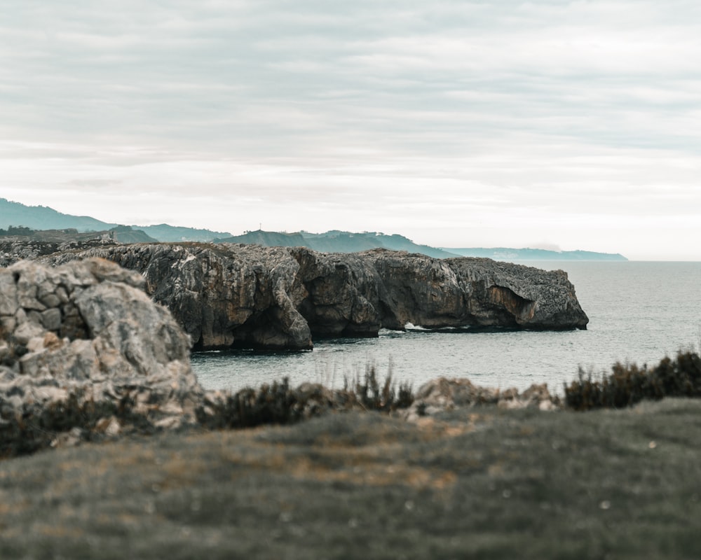 gray rock formation on sea at daytime