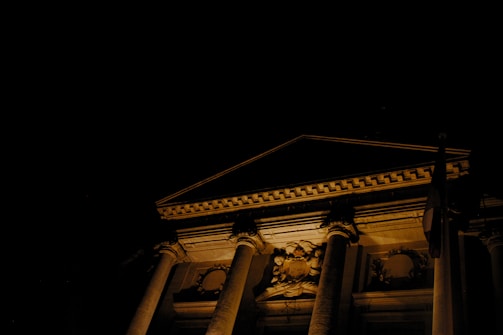 Night view of a building exterior highlighting illuminated decorative elements.