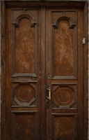 A rustic wooden front door with intricate carvings and a brass handle.