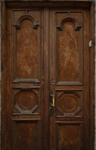 Classic wooden door with carved details and brass handle