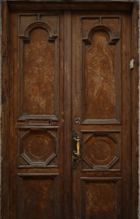 Finished wooden door with geometric carved designs displayed in a showroom