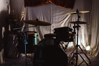 A beginner drum kit set up in a bright room with sunlight streaming through the window.