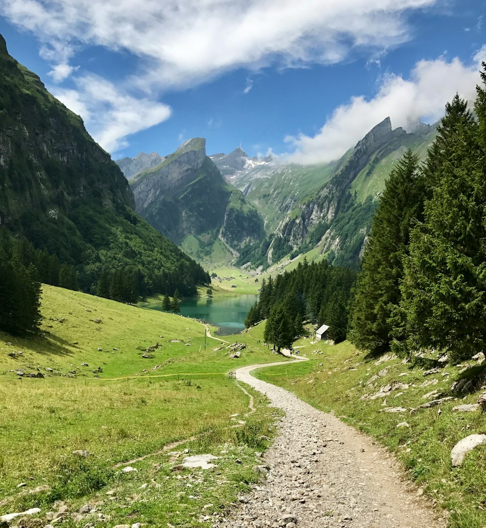 calm body of water in between of mountain during daytime