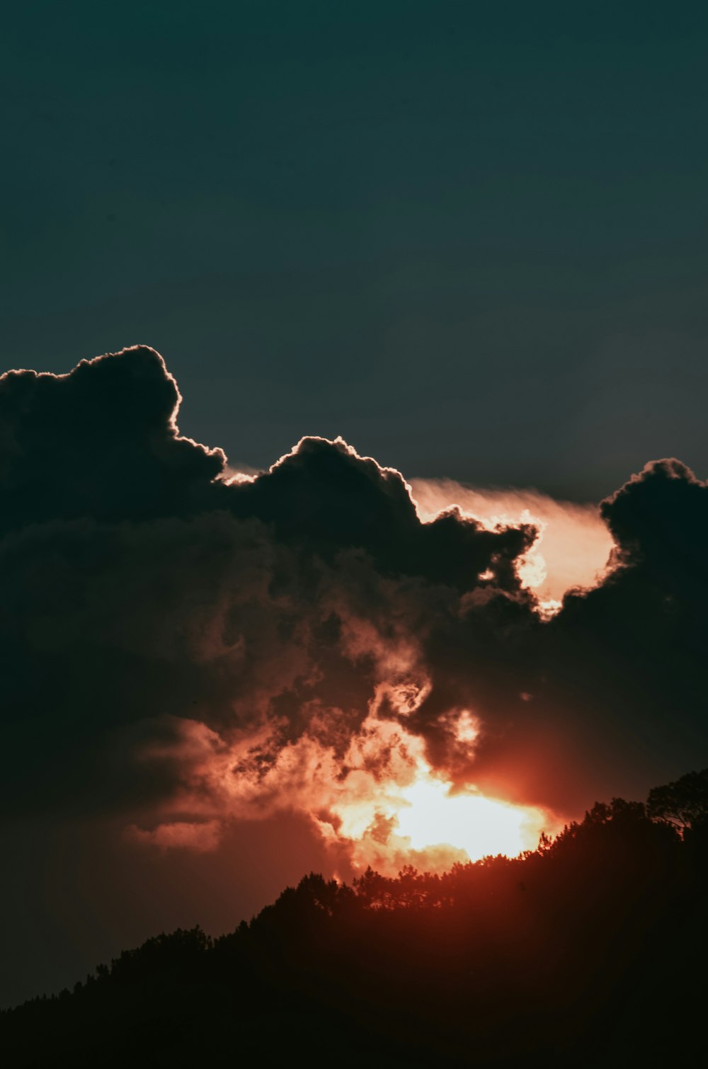 silhouette de montagne sous ciel nuageux pendant l’heure dorée