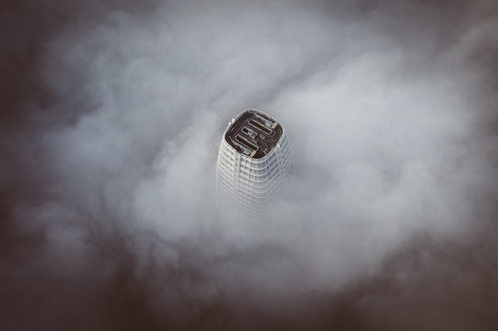 Edificio de hormigón blanco rodeado de nubes