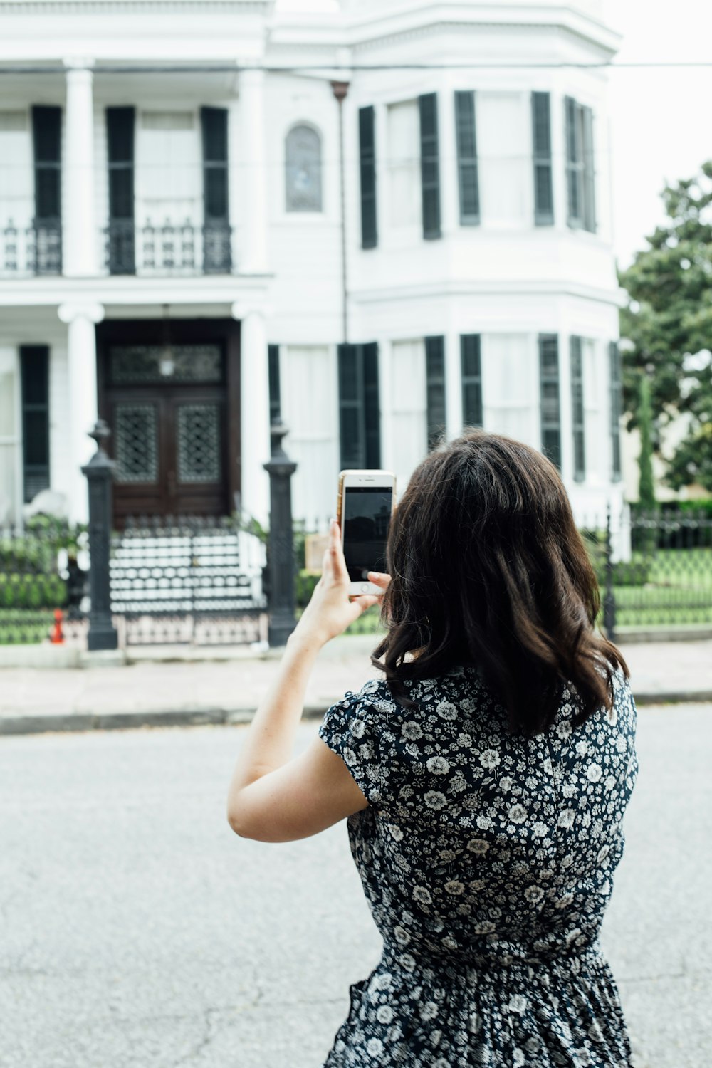woman taking photo of house