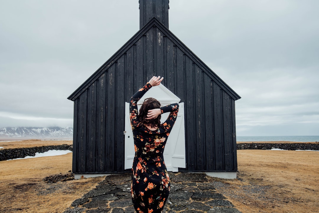 woman standing in front of black and white shed