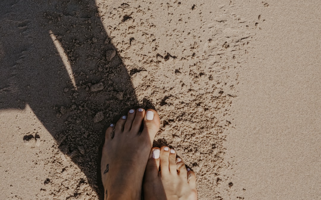 person stepping on sand