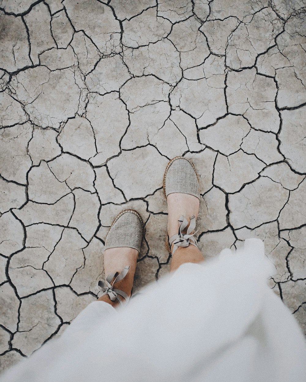 woman in gray flats standing on dried field