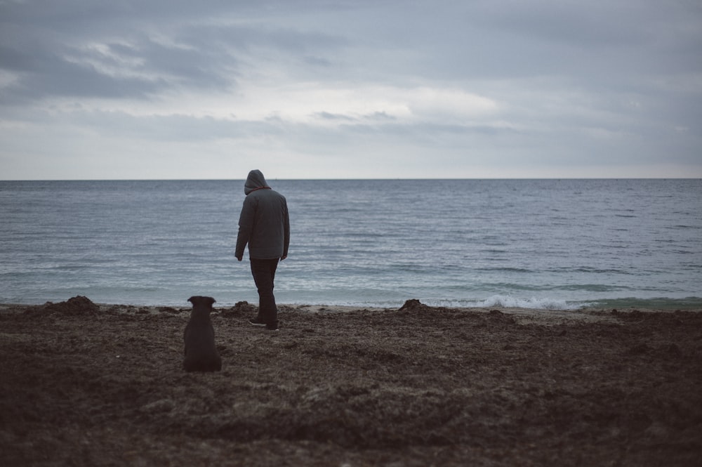 person standing in front of body of water during daytime