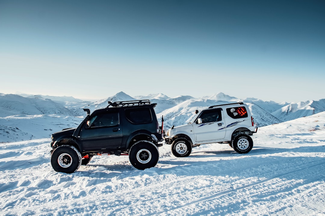 two white and black SUV on snow path