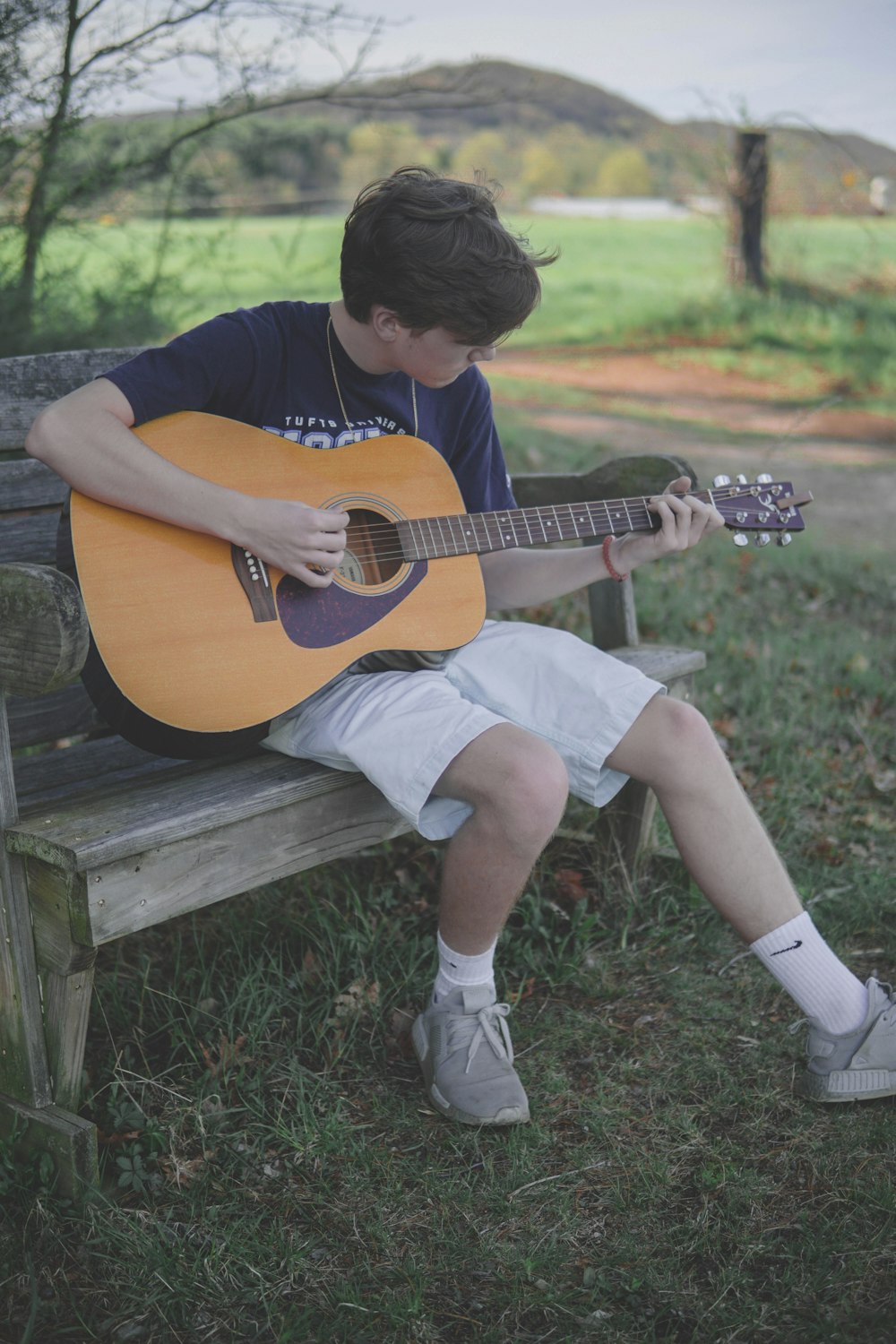 man playing brown acoustic guitar