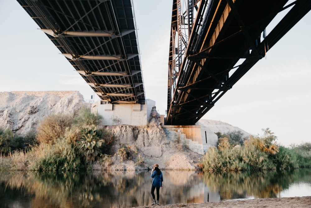 Persona in piedi sotto il ponte marrone