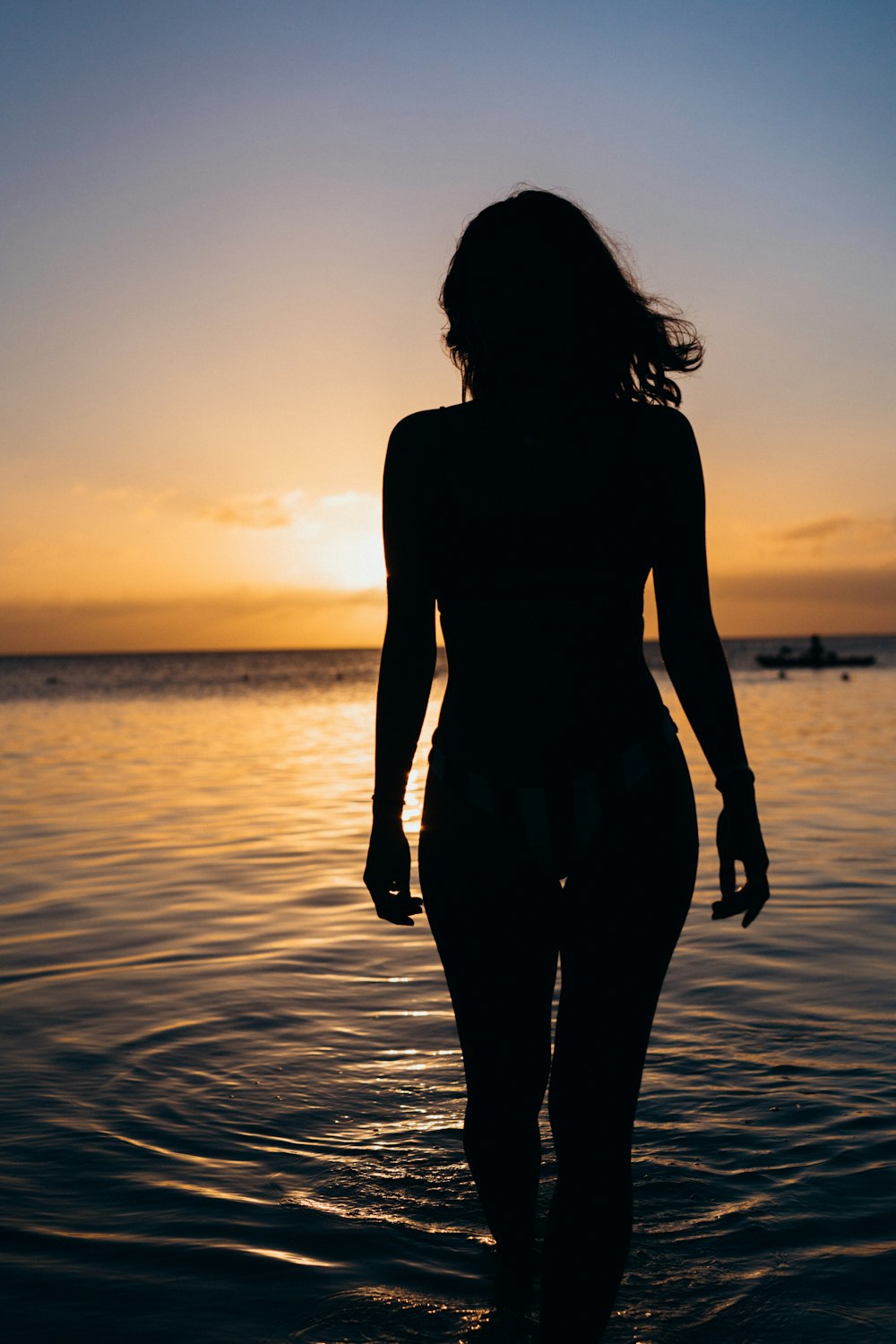 silhouette di donna in piedi n corpo d'acqua