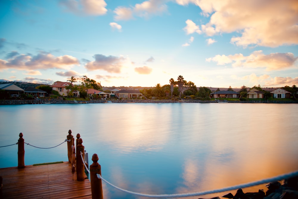 brown wooden dock with houses background