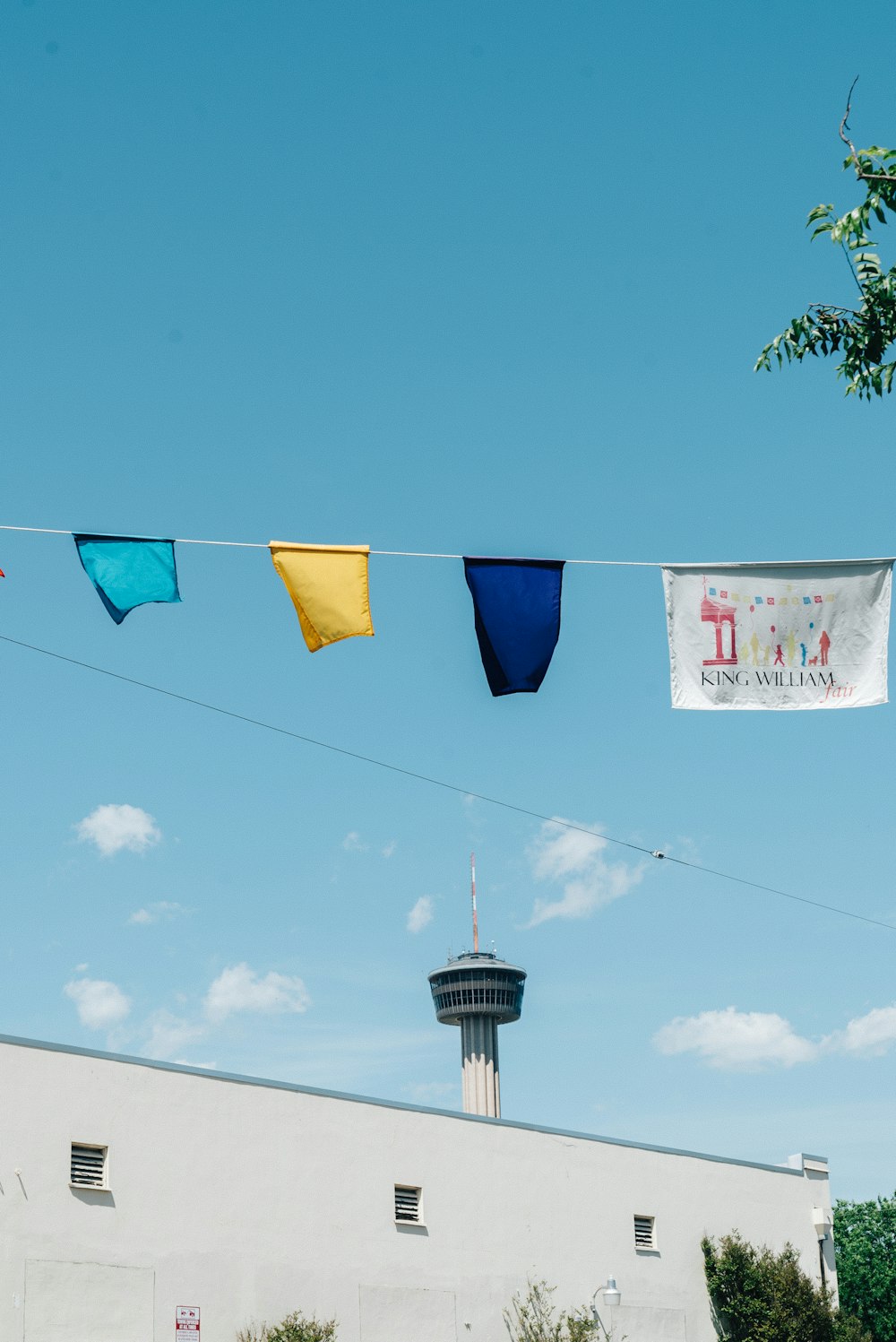 teal, yellow, blue and white textiles on string during daytime