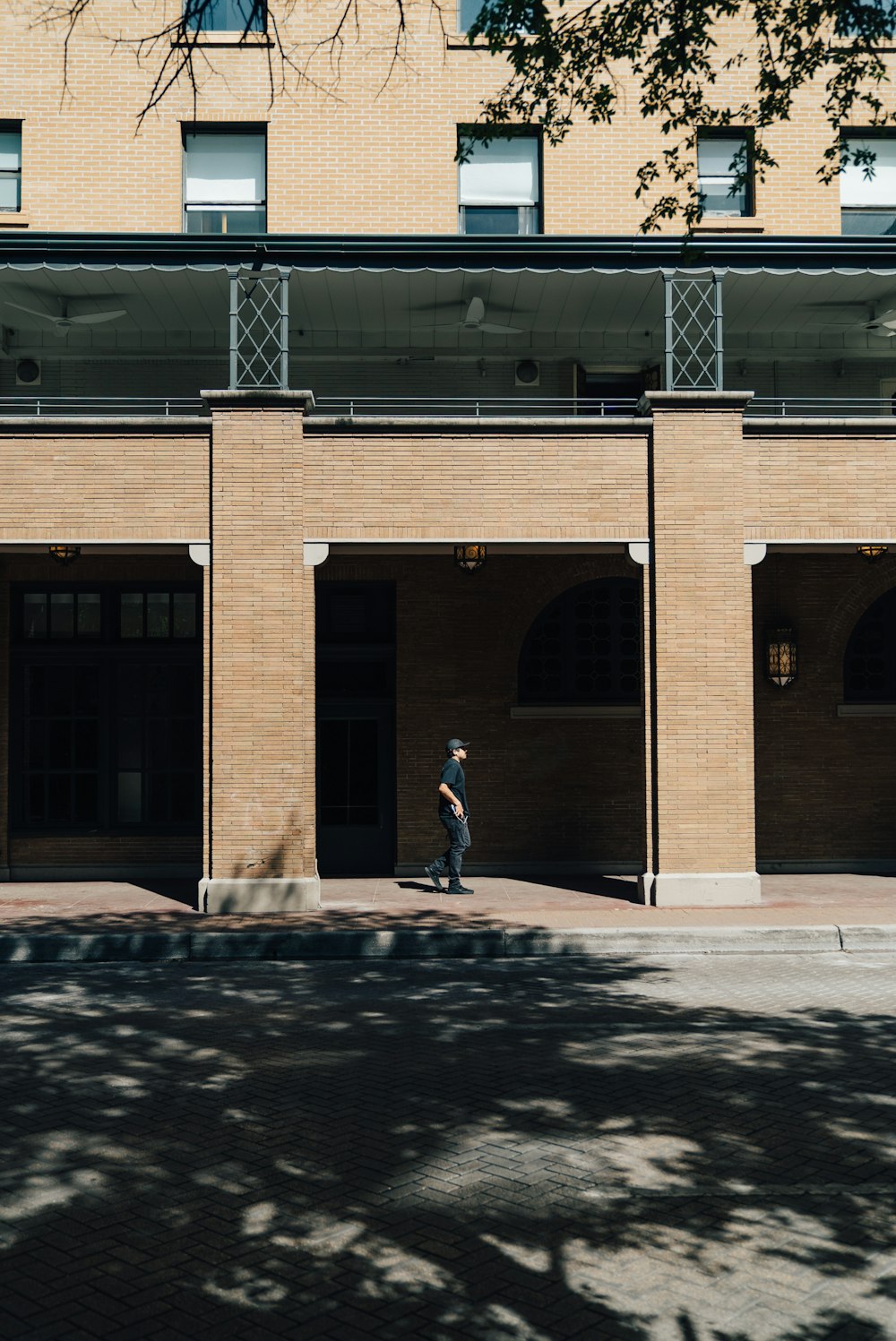 Persona que camina debajo de un edificio de concreto marrón durante el día
