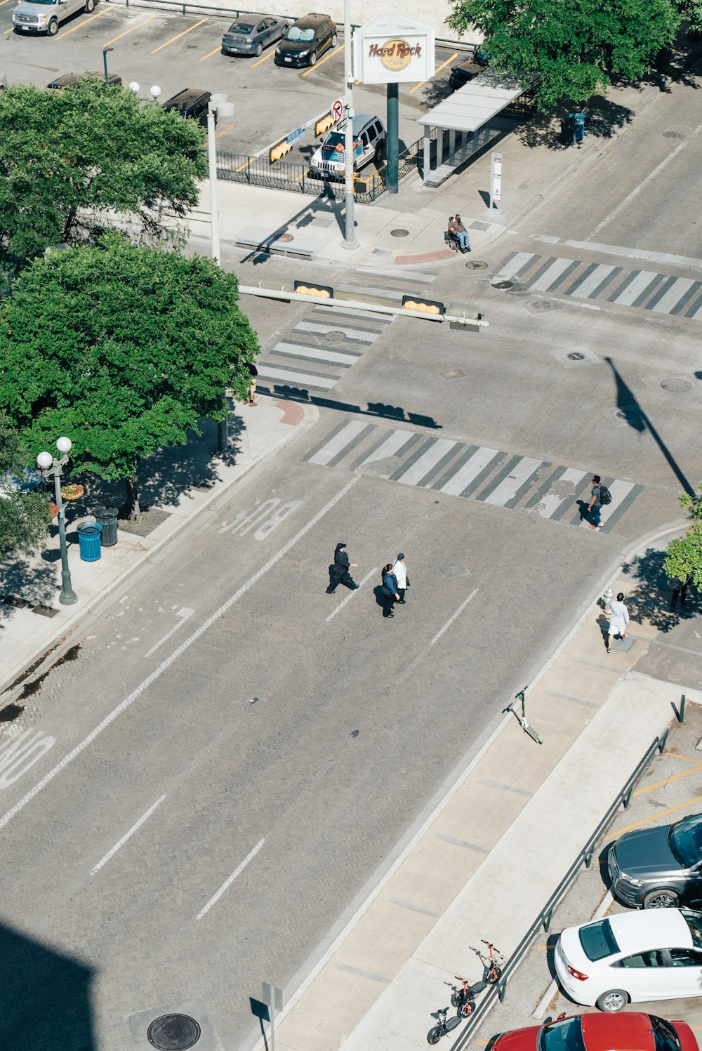 aerial photography of three men crossing road