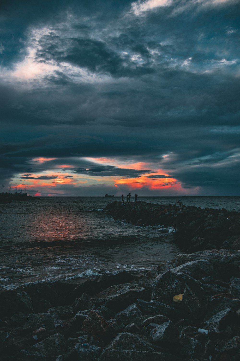 people by the beach under grey clouds