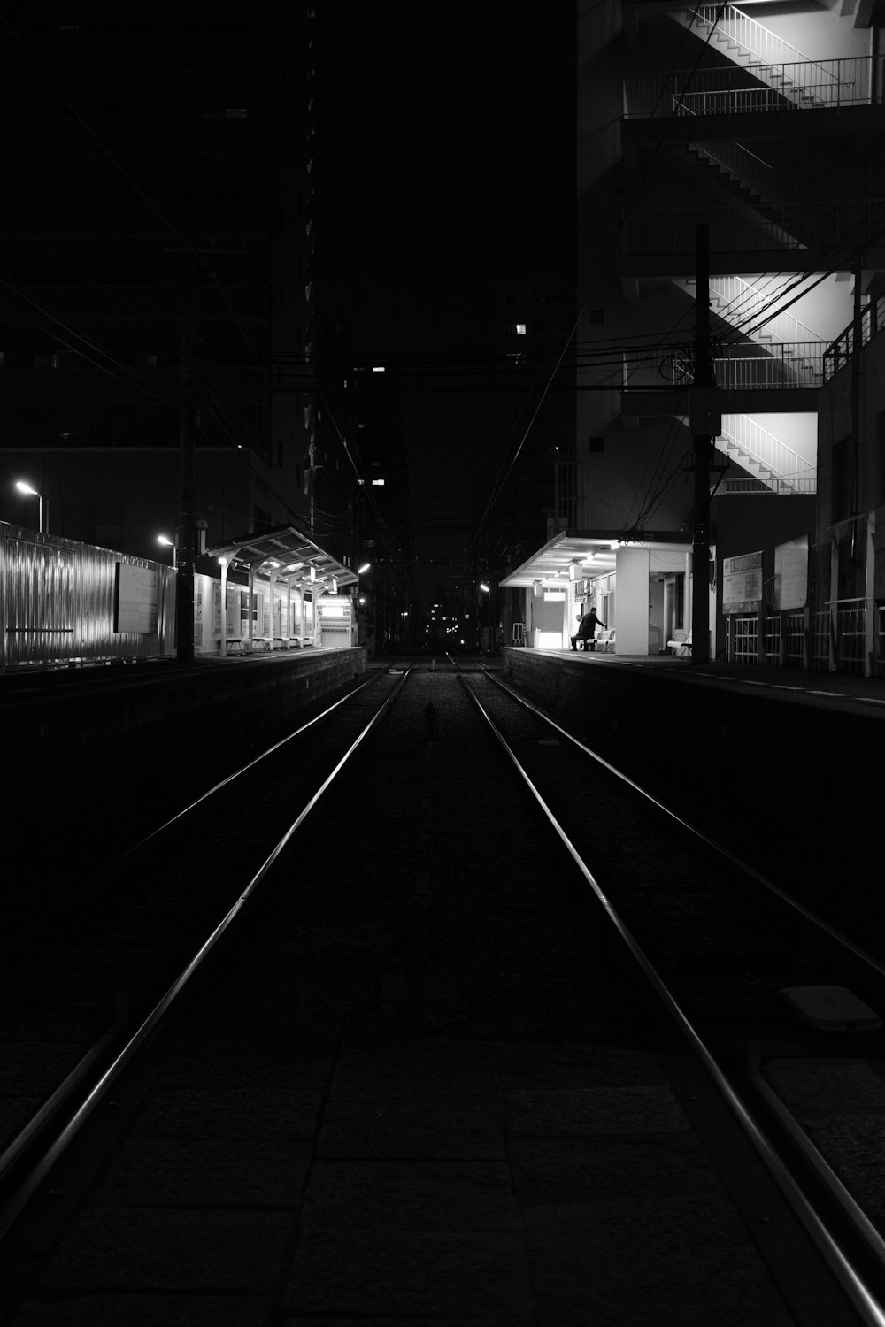 a black and white photo of a train station at night