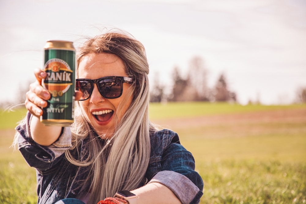 woman holding soda can