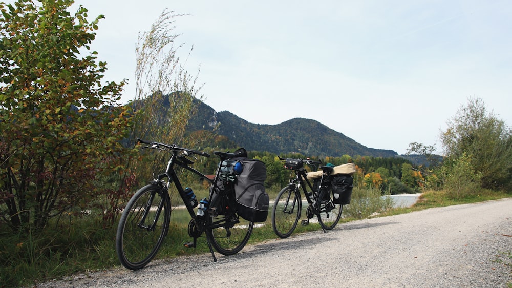 two mountain bikes parked by the road overlooking mountain during daytime
