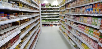 A well-stocked supermarket aisle with fresh produce and grocery items.