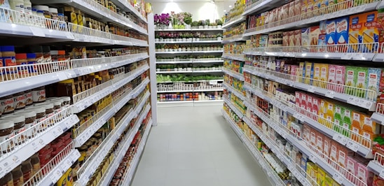 Well-stocked grocery store aisle with fresh produce and various products