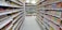 A happy customer shopping in a well-stocked store aisle.