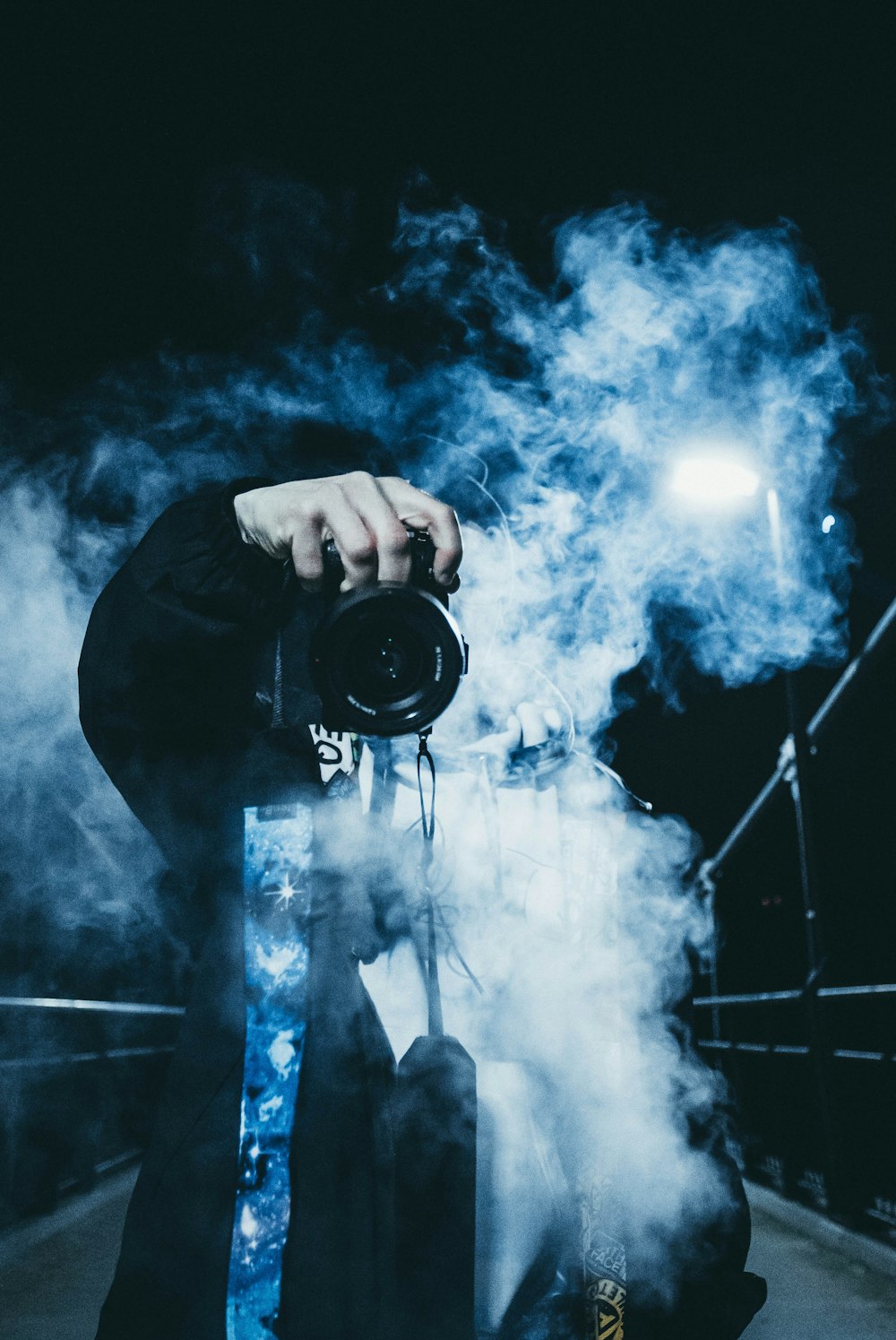 person using DSLR camera near white smoke