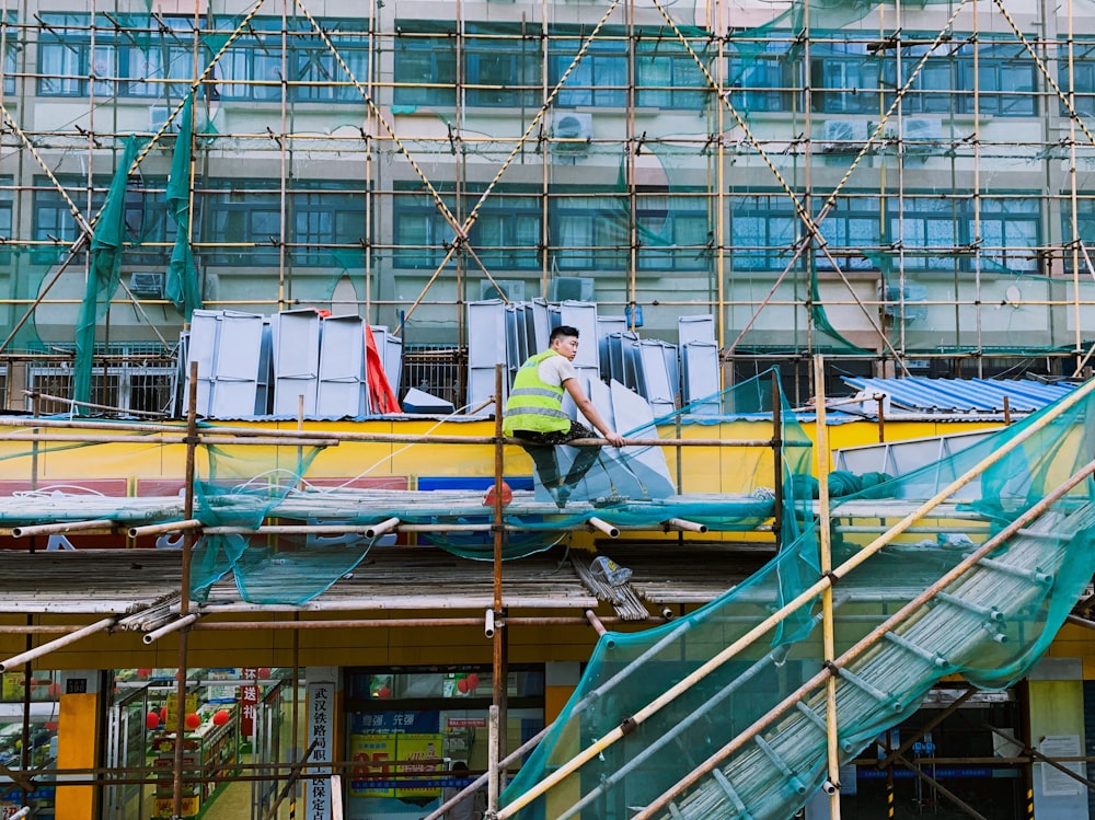 man sitting on scaffolding
