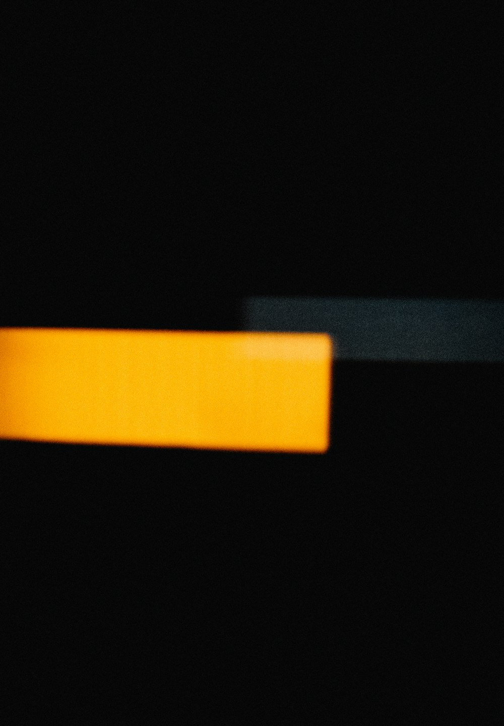 a blurry photo of a yellow object in the dark