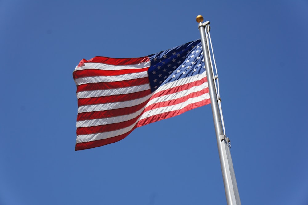 a large american flag flying in the wind