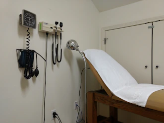 Doctor consulting with a patient in a warm, private exam room.