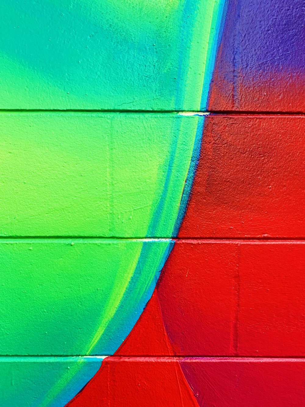 Mur de briques peintes en vert, bleu et rouge