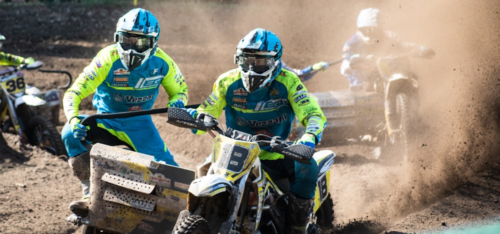 racers riding trike dirt bikes on dusty ground during daytime