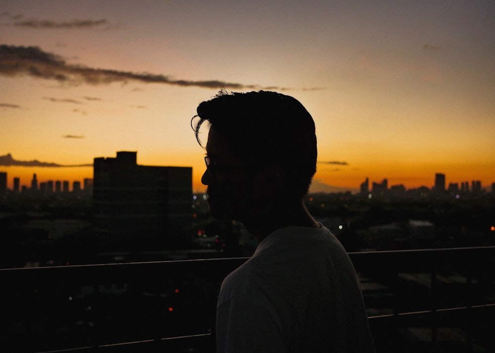 man standing near railings viewing city