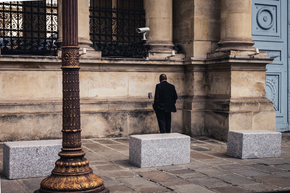 a man in a suit standing in front of a building