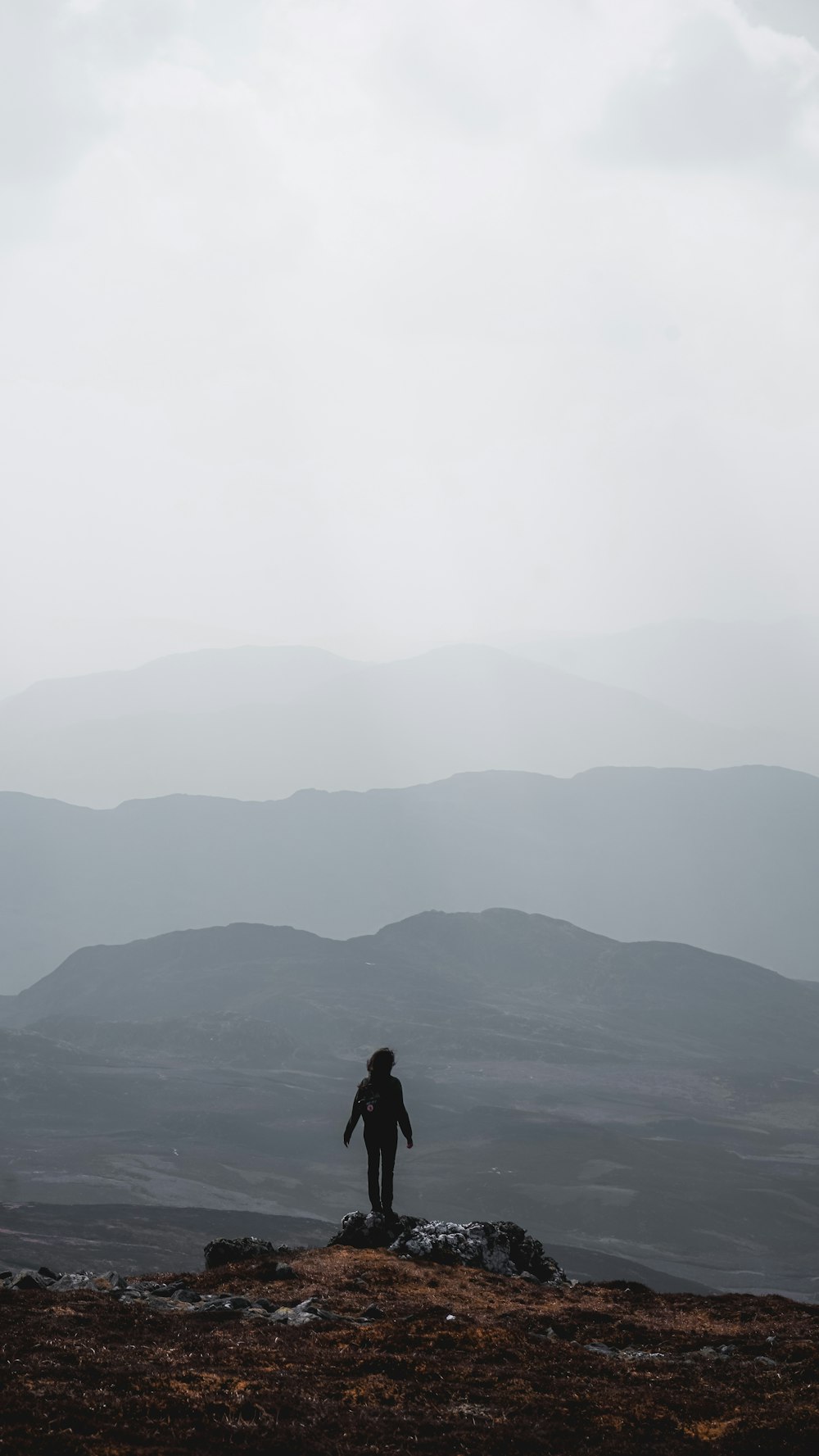 person standing on side of cliff during daytime