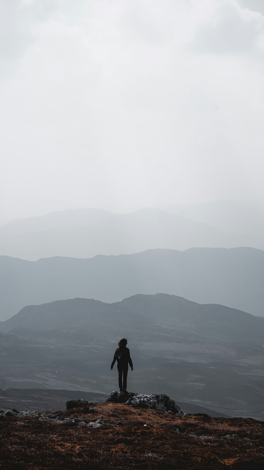 person standing on side of cliff during daytime