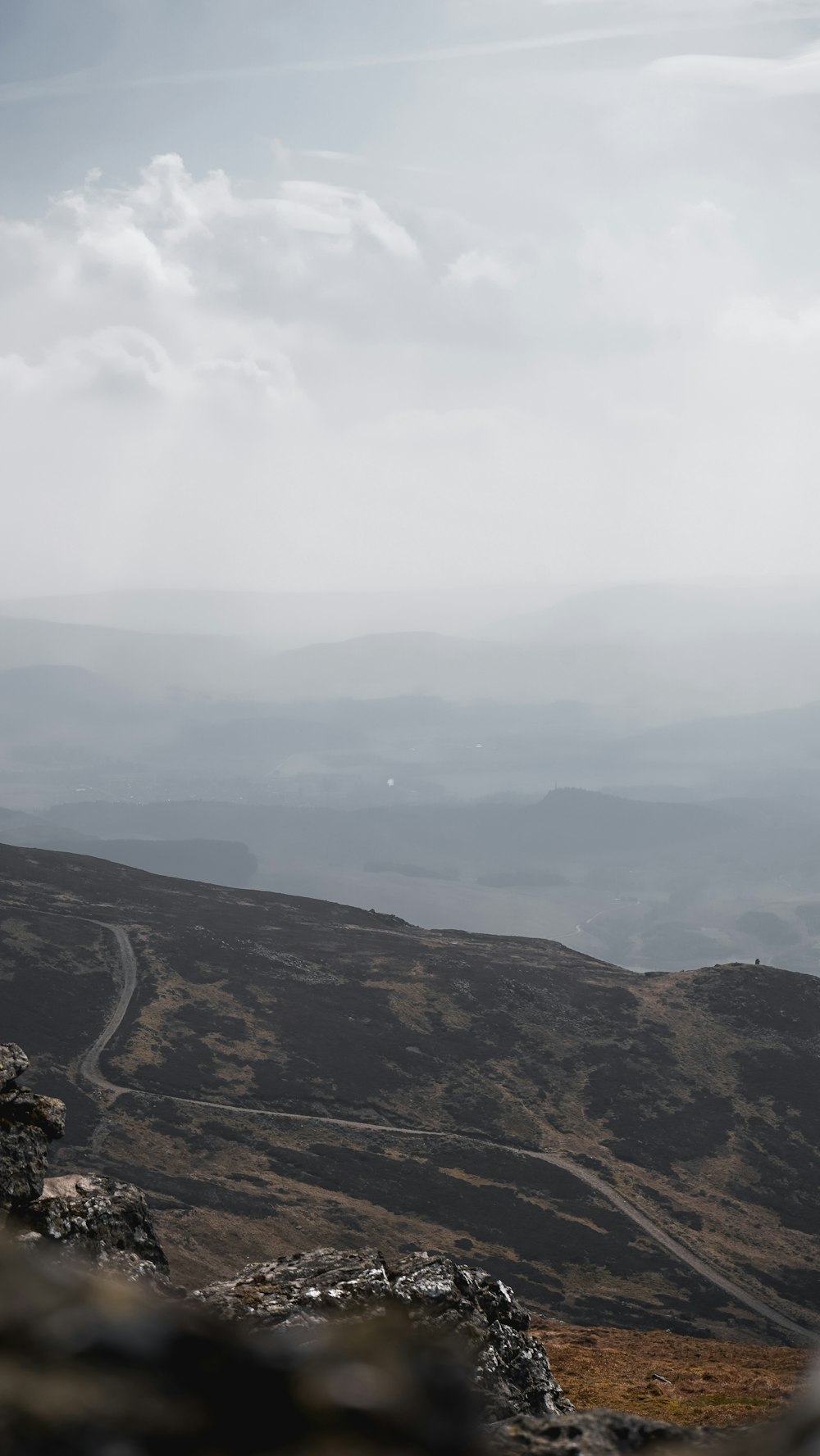 aerial view of green and brown mountains under cloudy sky during daytime