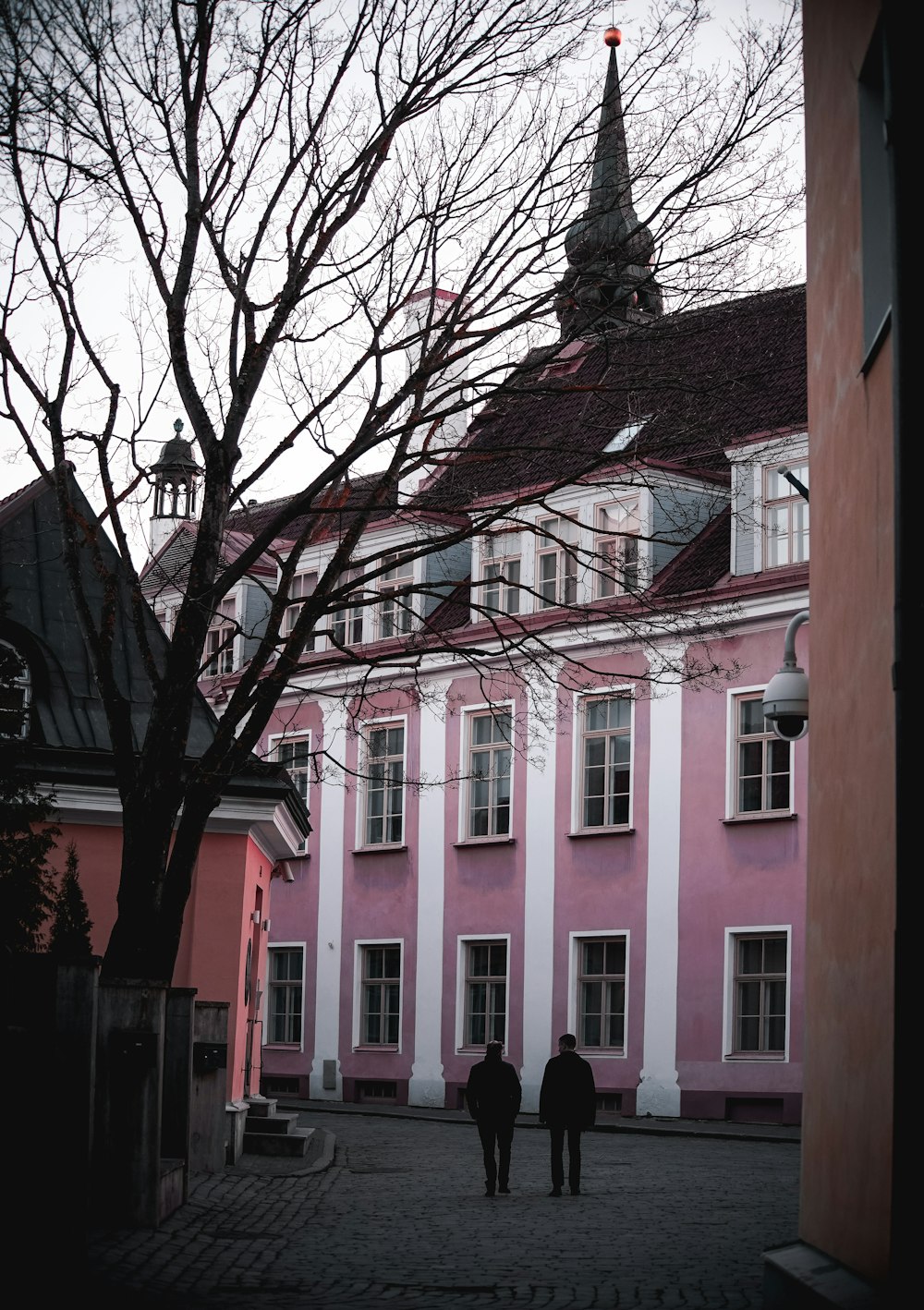 two men standing beside building