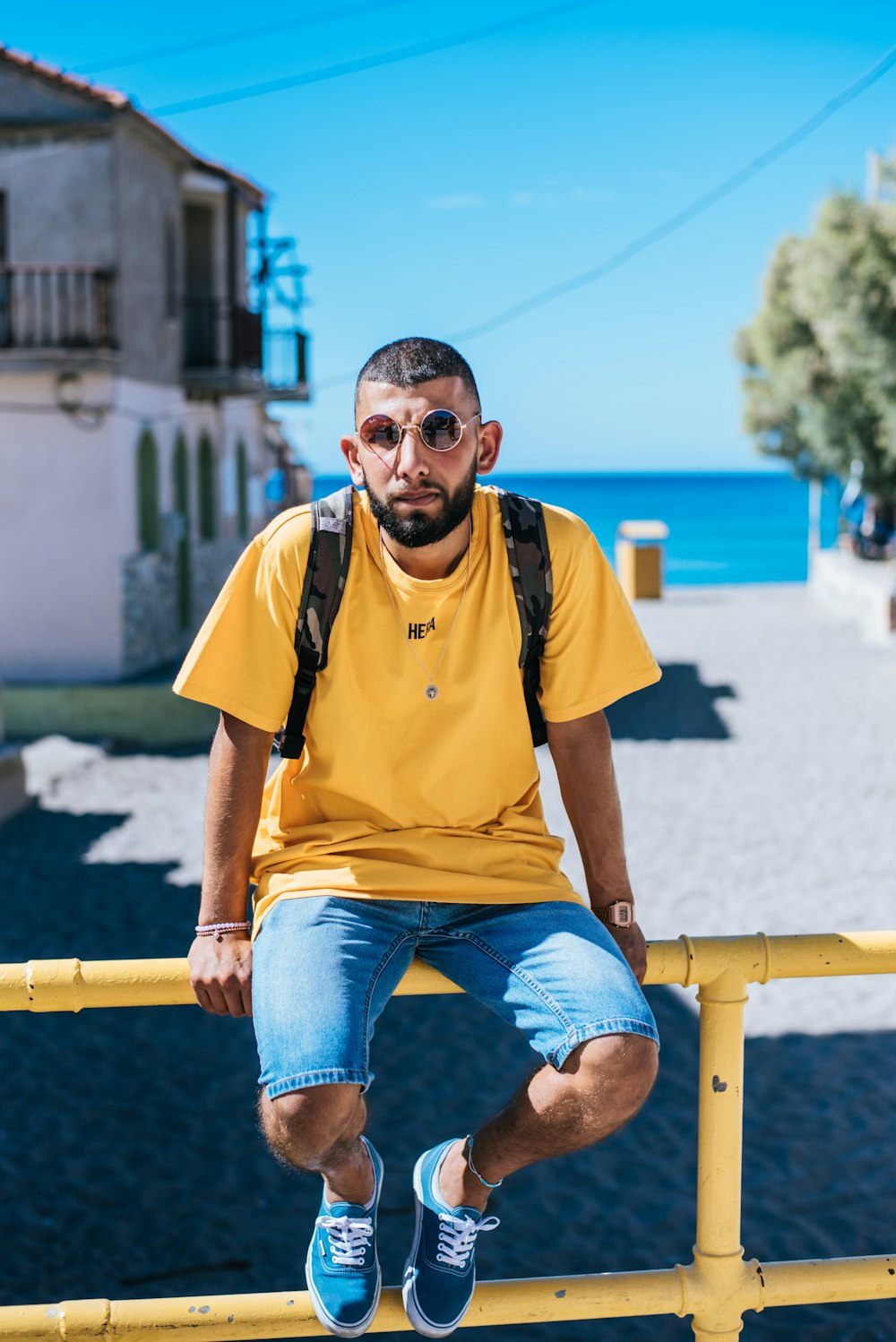 man in yellow T-shirt sitting on metal bar