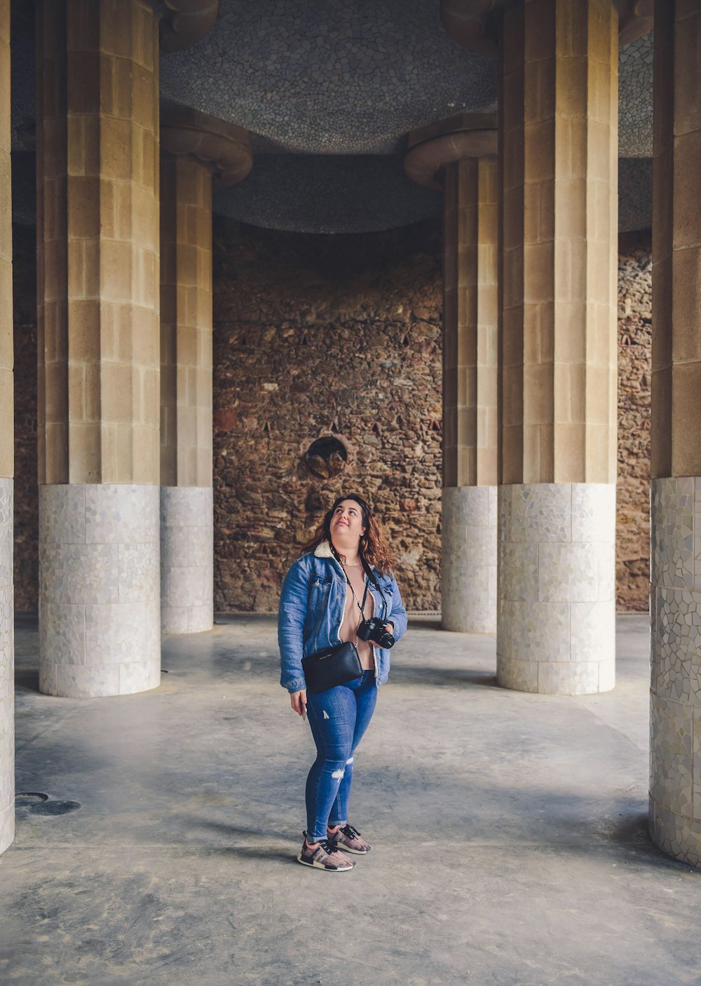 woman wearing denim jacket looking upward