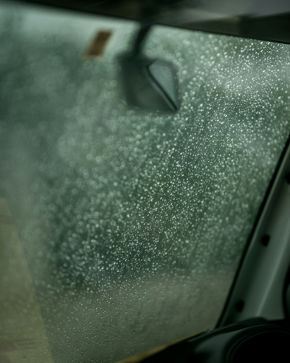 a car door with rain drops on the glass