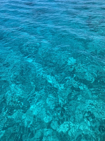 Close-up of crystal-clear turquoise water with sunlight reflecting, showcasing the lagoon's stunning colors.
