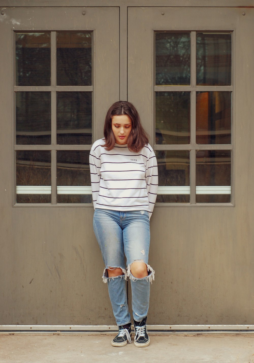 woman leaning on two glass doors